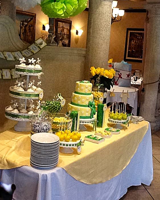 Green and yellow themed dessert display with tiered cakes and cake pops