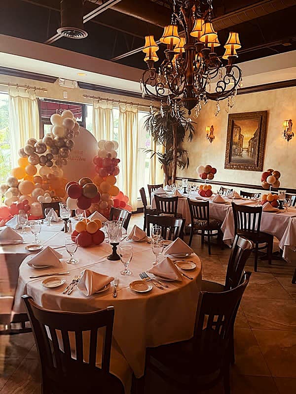 Rose-gold balloon arch celebration with ornate chandelier