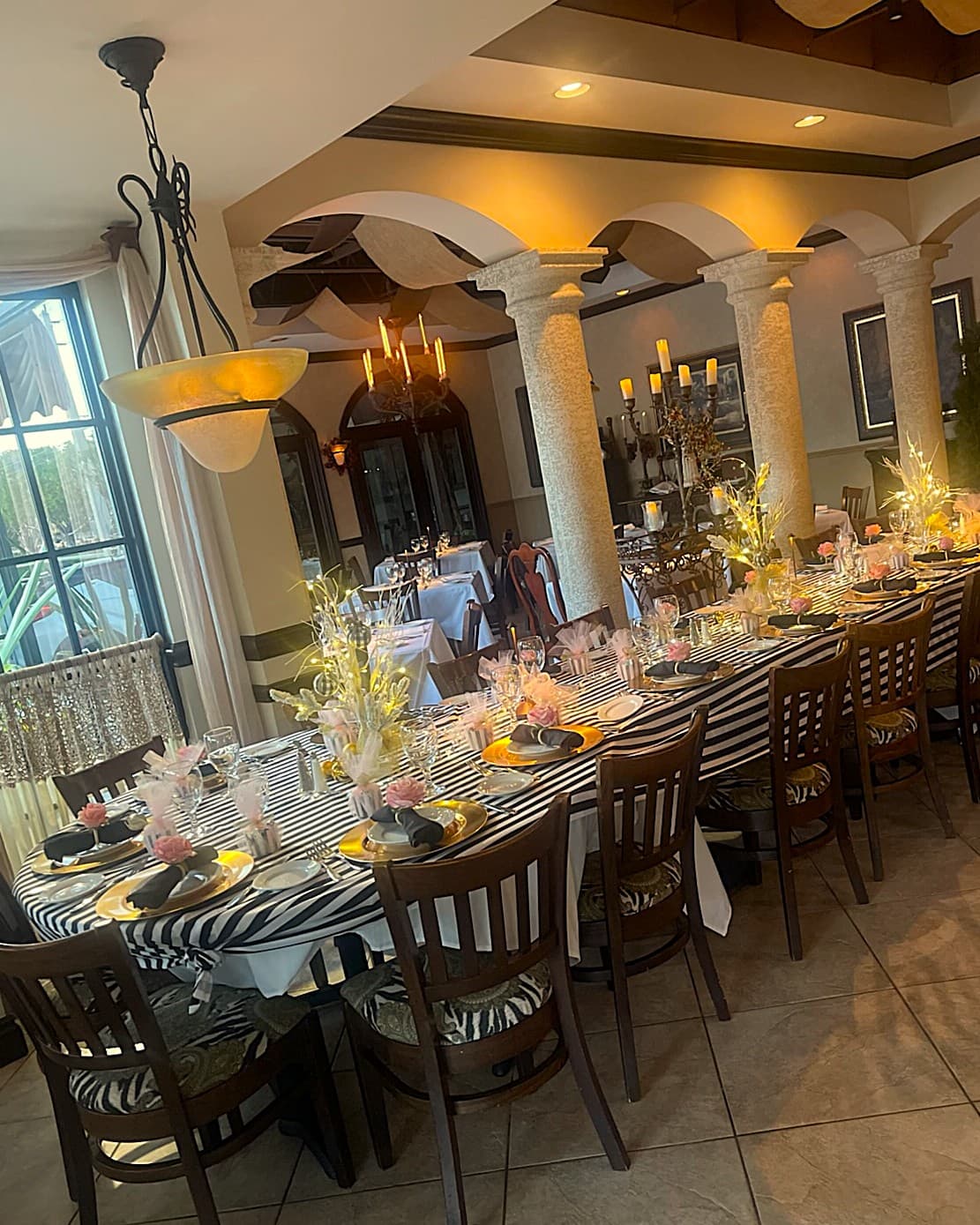 Elegant dinner with black and white striped table runner and gold place settings